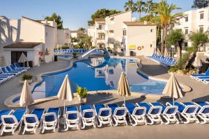 a pool with chairs and umbrellas at a resort at Cabot Club Torreblanca in Sa Coma