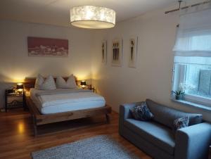 a bedroom with a bed and a couch at Pension Temizdemir in Lahr