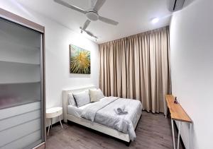 a bedroom with a bed and a table and a window at MySky Putrajaya in Putrajaya