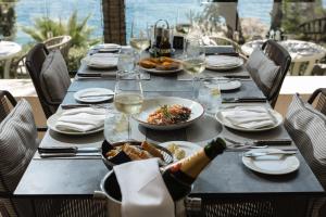 a table with plates of food and wine glasses at Royal Neptun Hotel in Dubrovnik