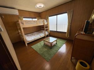 a bedroom with two bunk beds and a window at Haraya in Nakatsugawa