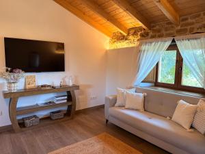a living room with a couch and a tv at La casa de Tio Mines in Regolfo