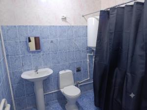 a blue tiled bathroom with a toilet and a sink at Хостел18А in Nukus +7 photos