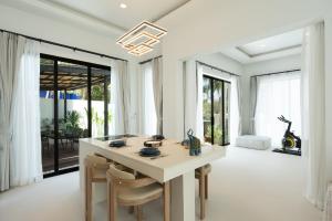 a kitchen with a large white island with chairs at Eterno Villas in Salad Beach +75 photos