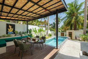 an outdoor patio with a table and chairs and a swimming pool at Eterno Villas in Salad Beach