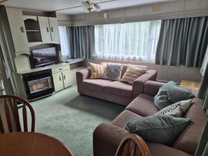 a living room with two couches and a television at Juno Holiday in Mrągowo