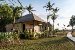 ein Haus mit Palmen davor in der Unterkunft Hotel Lumi Gili Trawangan in Gili Trawangan