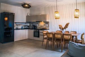 a kitchen and dining room with a table and chairs at K Villas in Plataria