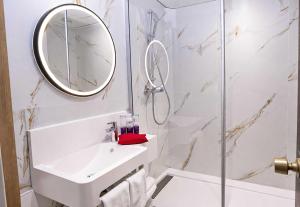 a white bathroom with a sink and a mirror at B&B HOTEL Nîmes Ville Active 3 étoiles in Nîmes