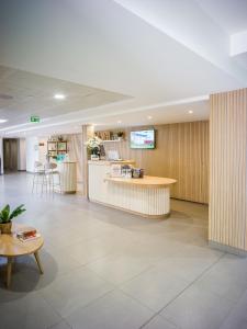 a lobby of a hospital with a counter and chairs at BRIT HOTEL CONFORT Roissy Saint-Witz in Saint-Witz
