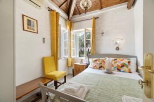 a bedroom with a bed and a yellow chair at Giannis Mountain House in Aigio