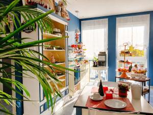 a kitchen with blue walls and a table with plates at Hotiday Ferrara Centro in Ferrara