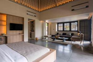 ein Schlafzimmer mit Bett und ein Wohnzimmer in der Unterkunft Hotel Lumi Gili Trawangan in Gili Trawangan