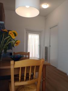 a dining room with a table and a vase of flowers at Appartamento con giardino e posto auto privato in Follonica