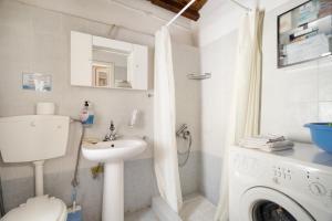 a bathroom with a toilet sink and a washing machine at Giannis Mountain House in Aigio +21 photos