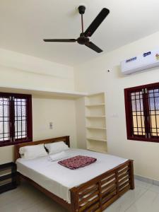 a bedroom with a bed with a ceiling fan at Ecstasy Homestay Puducherry in Pondicherry