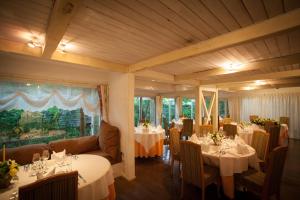 a restaurant with white tables and chairs and a room at Auberge de Primavera in Karuizawa