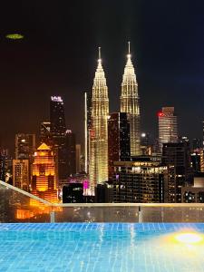a view of a city skyline at night at The Luxe Service Suites in Kuala Lumpur