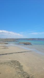 a sandy beach with rocks in the water at Flechimar Suítes in Trairi +4 photos