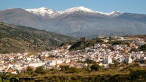 a town with snow capped mountains in the background at Casa de los Yayos in Vélez de Benaudalla