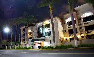a building with a clock on the side of it at night at EH Ejecutivo Urban in Tepic