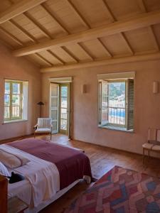 a bedroom with a large bed in a room with windows at Casa Mediterraneo Hotel in Meyisti