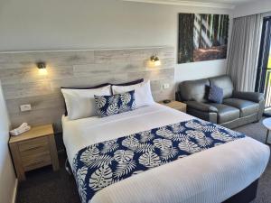 a hotel room with a bed and a chair at Apollo Bay Waterfront Motor Inn in Apollo Bay