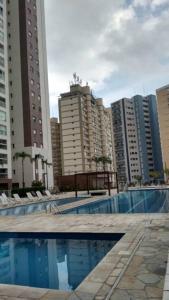 a swimming pool in a city with tall buildings at Apartamento Lazer Orquídeas in Santos