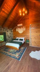 a bedroom with a bed and a stone wall at Lavinya Suit Bungalov in Rize