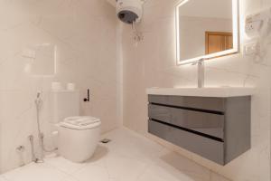 a white bathroom with a toilet and a sink at Elevana Boutique hotel in Cairo +186 photos