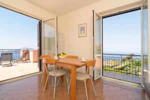 a dining room with a table and chairs and a balcony at Sunset Capri by Espresso Rentals in Massa Lubrense