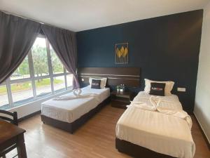 a bedroom with two beds and a large window at Alia Express Sendayan in Kampong Gadong Jaya
