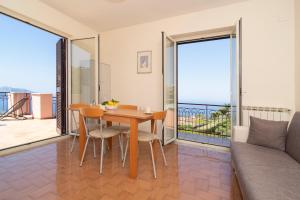 a living room with a table and chairs and a couch at Sunset Capri by Espresso Rentals in Massa Lubrense