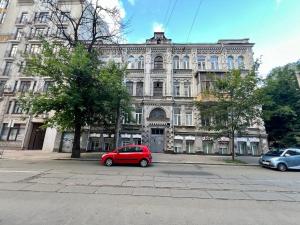 a red car parked in front of a large building at Podil-House-Hotel in Kyiv