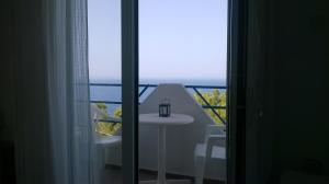 a room with a table and a view of the ocean at Haris Apartments in Armenistis