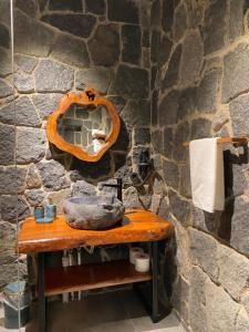 a stone walled bathroom with a wooden table with a sink at Lavinya Suit Bungalov in Rize +58 photos
