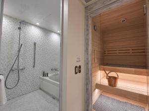 a bathroom with a shower and a bath tub at Auberge de Primavera in Karuizawa