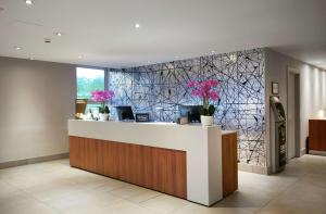 a lobby with a counter with flowers on the wall at Hilton London Croydon in Croydon