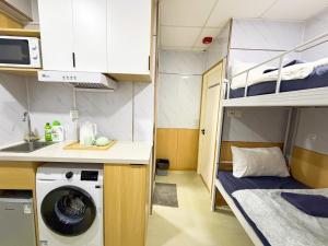 a kitchen with a washing machine in a small room at 利園賓館 in Hong Kong