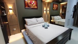 a bedroom with a bed with a teddy bear on it at Grand Riviera suites Manila Condo infront of us embassy in Manila