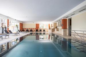 a swimming pool in a building with tables and chairs at Banders Landhaus in Imst