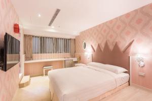 a bedroom with a large bed and a television at RF Hotel - Sanchong in Taipei
