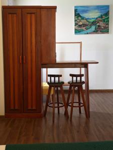 a wooden table with two stools next to a cabinet at Vangvieng Lina hotel in Vang Vieng