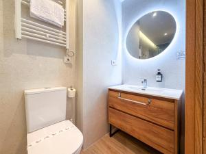 a bathroom with a toilet and a sink and a mirror at Apartamentos Liérganes Centro II in Liérganes +29 photos