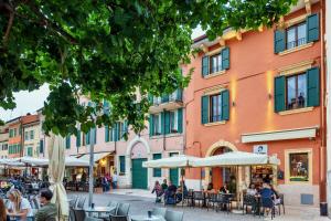 a street with tables and umbrellas in front of a building at Zeno Suites in Verona