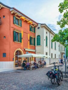 a group of people sitting at tables in front of a building at Zeno Suites in Verona