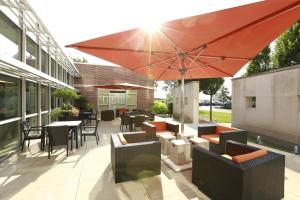 a patio with tables and chairs and an umbrella at I Hotel and Illinois Conference Center - Champaign in Champaign