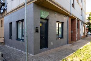 a building with black doors on the side of it at Apartamentos Liérganes Centro II in Liérganes