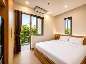 a bedroom with a bed and a large window at Minh Khang Apartment in Danang