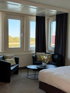a hotel room with a bed and two chairs and a table at Hotel am Rhein in Wesseling +46 photos